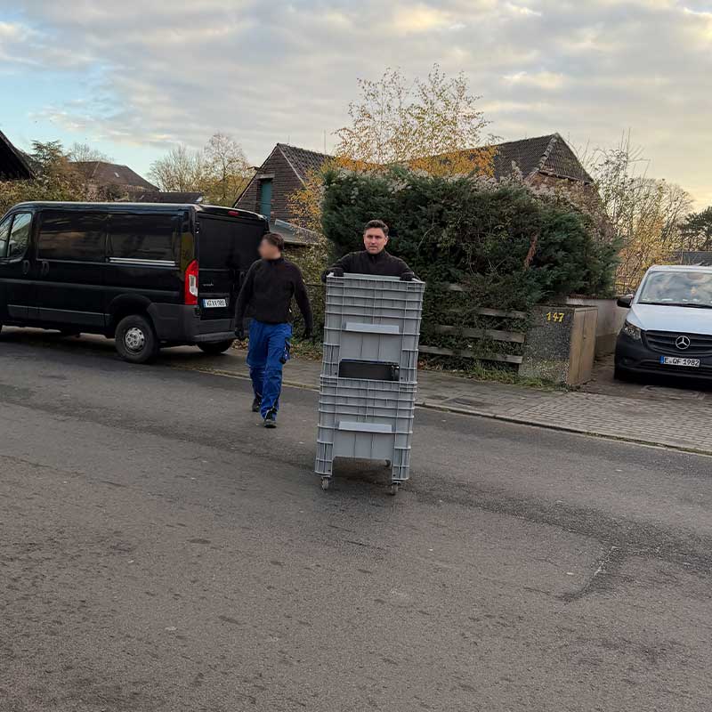 Umzugshelfer transportiert Rollboxen für einen strukturierten Wohnungsumzug